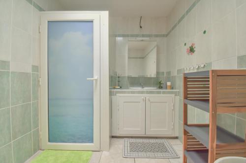 珀蒂蒂勒AU MEUBLE DURANTAS的浴室设有通往水槽的门
