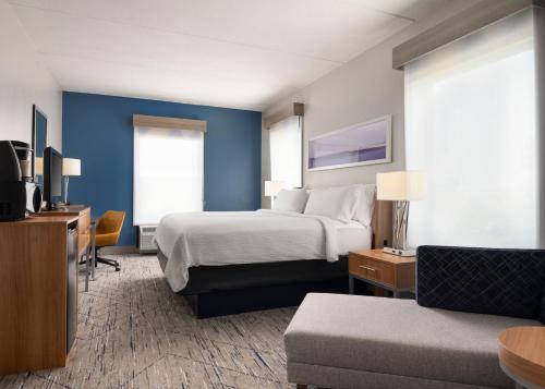 Saint Rose新奥尔良机场智选假日酒店及套房的酒店客房,配有床和沙发