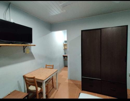 Les LagunesAirport Premier Hotel的客房设有桌子、电视和木柜。