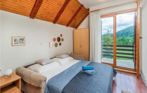 拉夫纳格拉Nice Home In Ravna Gora With Wifi的一间卧室设有一张大床和一个大窗户