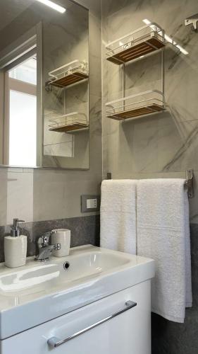 卡拉拉Bilocale Carrara Centro con giardino e parcheggio moto的白色的浴室设有水槽和镜子