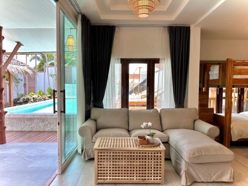 奥南海滩Villa Vara - Tropical Pool Villa的客厅配有沙发和桌子