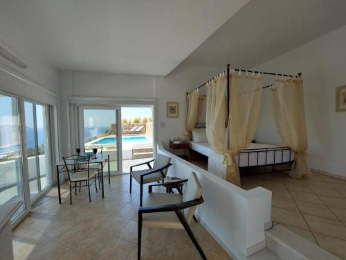 阿纳菲Apollon Village Hotel的一间卧室配有床和椅子,还有一个游泳池