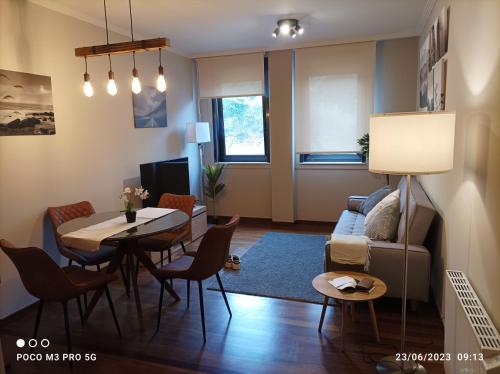 比韦罗Apartamento Piscina 2G by Urraca Suites Viveiro的客厅配有桌子和沙发