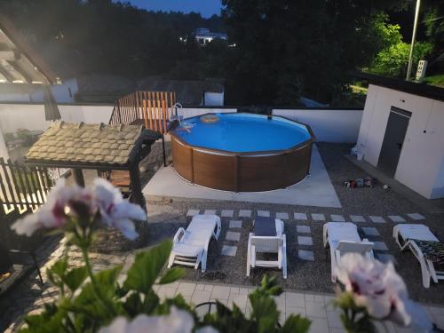 维尔蒂尼克Vila Jovana的后院设有热水浴池、椅子和桌子