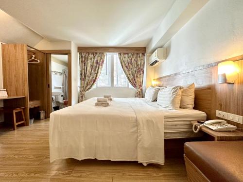 曼谷定索梦宾馆的卧室配有一张大白色床和窗户