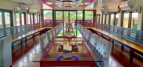 阿勒皮Meghavarsham Luxury cruise的大房间设有一张长桌和白色椅子