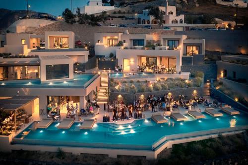 皮尔戈斯North Santorini - A Luxury Spa Hotel的享有房子空中景色,晚上有游泳池