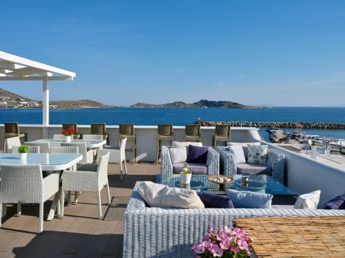 纳乌萨嘉里尼酒店的一个带桌椅的庭院和大海