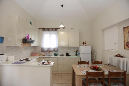 安德罗斯SummerAndros Meliti的厨房配有桌子和白色冰箱。