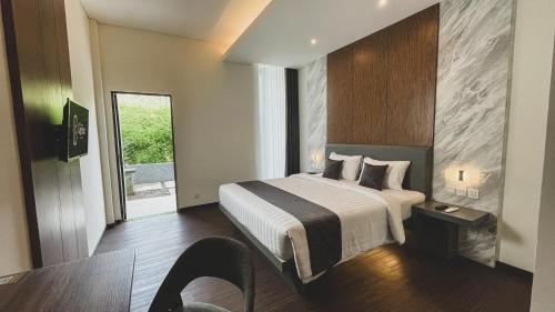 日惹LPP Garden Hotel的酒店客房配有一张床铺和一张桌子。