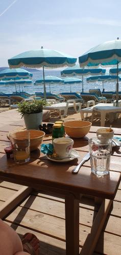 勒拉旺杜Appartement plein sud les Cyclades的海滩旁的木桌,上面放着碗