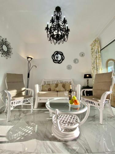 内尔哈SHR043 Nerja Medina Apartamento cerca de Playa Torrecilla的客厅配有吊灯和桌椅