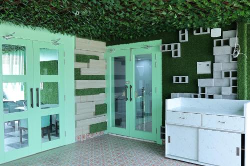 德拉敦Hotel 7 Heaven的浴室设有绿色的墙壁和玻璃淋浴间