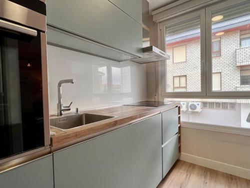 擞莫Acogedor apartamento en Somo的厨房设有水槽和窗户。