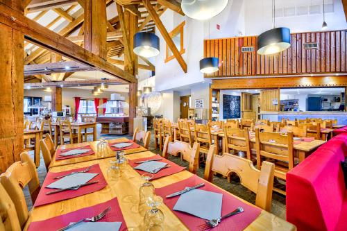 雷加霍斯达哈施莱塔瓦永乡村俱乐部度假村的用餐室配有木桌和椅子