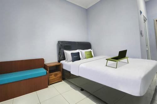 Urbanview Hotel Mutiara Persada Syariah Majalengka by RedDoorz的酒店客房,配有两张床和椅子