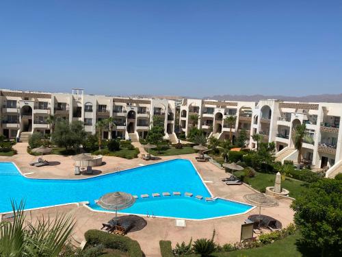 沙姆沙伊赫Renoviertes Luxusapartment Sunny Lakes 1 Sharm El-Sheikh nun auch für Langzeitmieter buchbar的享有带游泳池的大型公寓大楼的正面景色