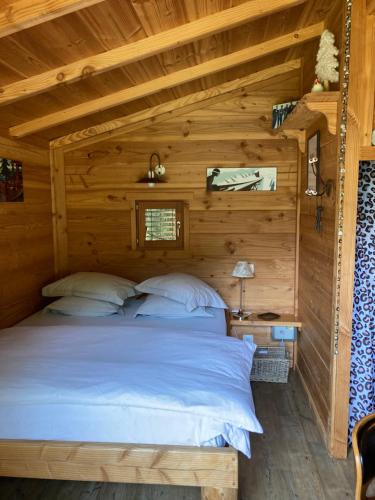 圣让多尔普la Cabane dans les Arbres的小木屋内的卧室,配有床