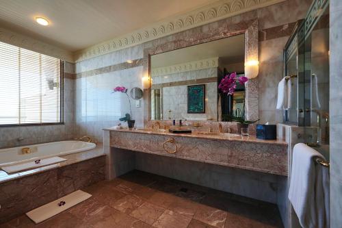 斯里巴加湾市The Empire Brunei的一间带浴缸和大镜子的浴室