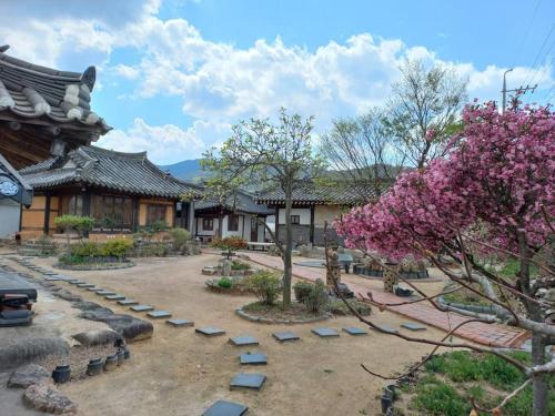 庆州Yasun Gallery的一座种有树木和岩石的庭院和一座建筑