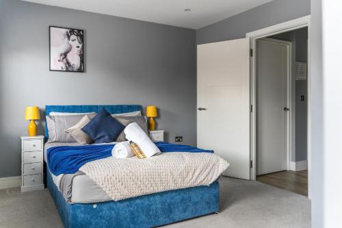 斯劳Livestay-One Bed Apt in Slough with FREE Parking的一间卧室配有蓝色的床和蓝色床头板