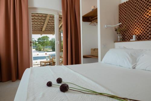 Leporano MarinaPozzo Traverso Casale的卧室配有带鲜花的白色床