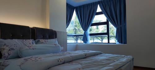 米里Sunsky Condominium Homestay 2的一间卧室配有一张带蓝色窗帘的床和一扇窗户