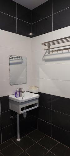 米里Sunsky Condominium Homestay 2的浴室设有水槽和黑白瓷砖。