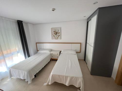 贝尼塔切利Apartamentos Flamingo Hills的带窗户的客房内的两张床