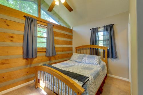格林维尔Family-Friendly Afton Cabin with Spacious Yard!的一间卧室设有一张婴儿床和木墙
