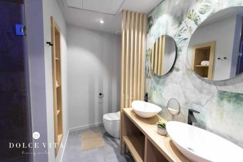 比亚雷亚尔Apartamento Milano Living Suites en Vila real的一间带水槽、卫生间和镜子的浴室