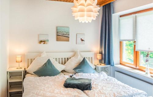 哈瑟尔贝格Awesome Apartment In Hasselberg With Kitchen的一间卧室配有白色床和蓝色枕头