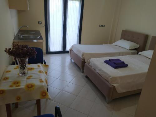 迪夫亚卡Vila M&D的酒店客房设有两张床和一张花瓶桌子