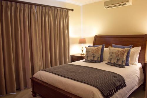 博福特西Bakgat Blyplek的一间卧室配有床和带窗帘的窗户