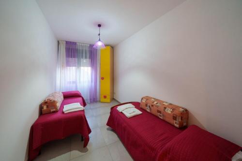 锡尔维玛丽娜B&B MELISSA的小客房内的两张床,配有红色床单