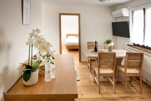弗尔赫尼卡Guesthouse Turšič的客厅设有餐桌,上面摆放着鲜花