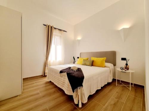 圣特奥多罗STAZZO SAN TEODORO IL GINEPRO的卧室配有一张带黄色枕头的大型白色床。