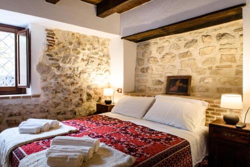 SantʼIonaLaVistaDeiSogni La Perla的一间卧室设有一张带石墙的大床