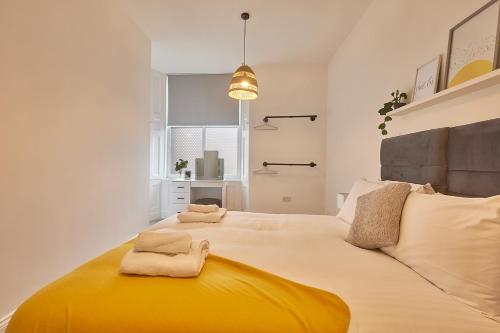 桑德兰5 Roker Terrace - Seaview apartments的一间卧室配有一张大床和毛巾