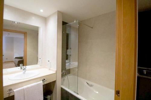 巴利亚多利德Alda Valladolid Sur的一间带水槽、淋浴和镜子的浴室