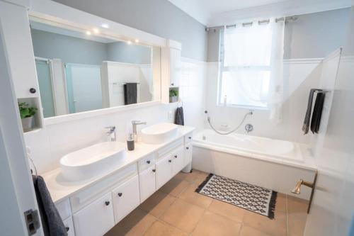 绍斯布鲁姆Sole Haven的浴室设有2个水槽、浴缸和镜子