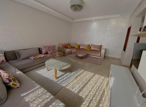 诺阿瑟Luxury résidence Taj Nouaceur的客厅配有沙发和桌子