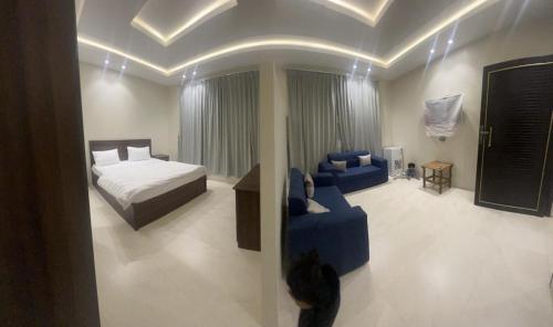 Ahad Rafidahوحدات جنان的一间卧室配有一张床和一张蓝色的沙发