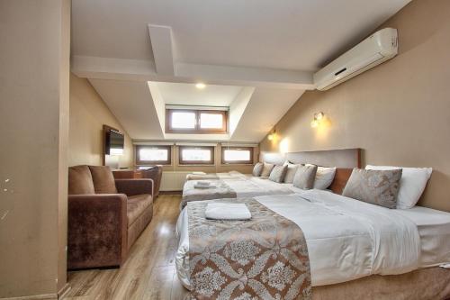 伊斯坦布尔Wide Suites Taksim的一间卧室配有一张大床和一张沙发