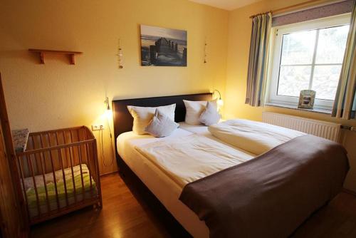 布利斯多夫Seerose的一间卧室设有一张床、一个窗口和一张婴儿床