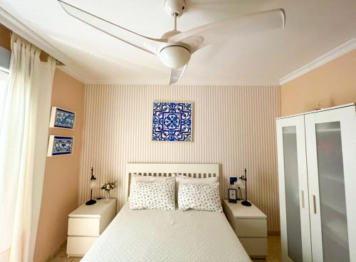 马拉加Como en casa的一间卧室配有一张床和吊扇