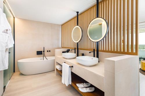 法鲁AP Eva Senses的浴室设有2个水槽、浴缸和镜子
