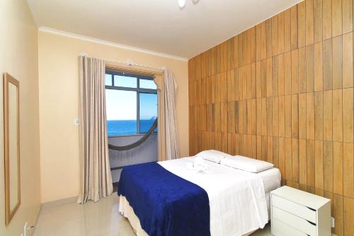 里约热内卢Rio Spot Homes vista praia D047的一间卧室设有一张床和一个海景窗户