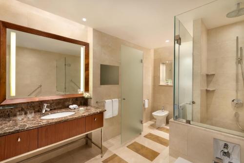 多哈JW Marriott Marquis City Center Doha的一间带水槽、淋浴和卫生间的浴室